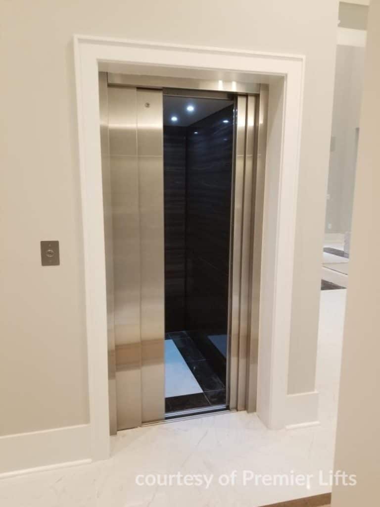 Open Savaria Eclipse home elevator with stainless steel doors and a dark interior.